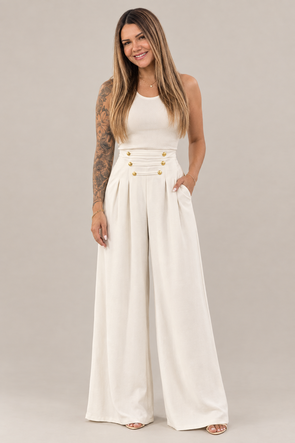 Modelo con pantalón italiano crema de pierna ancha y botones dorados