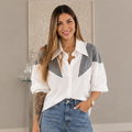 Vista cuadrada de la blusa blanca con detalles grises, de la cintura hacia arriba